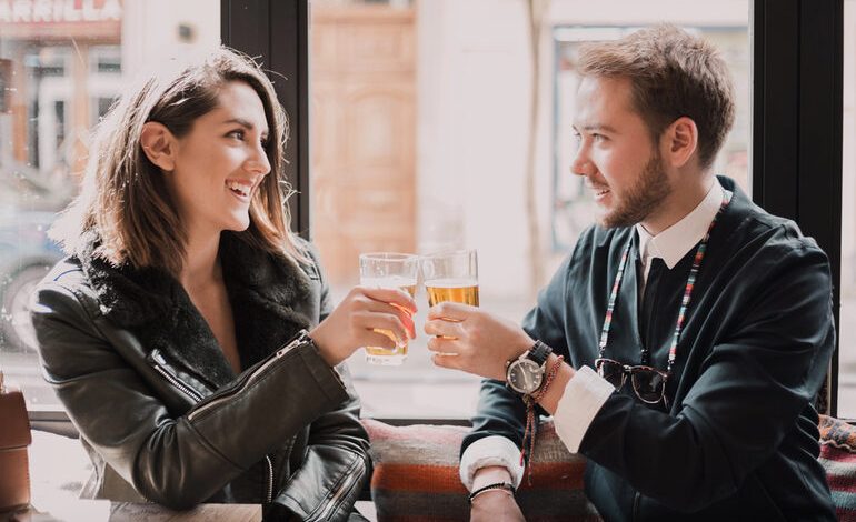 Smiling couple enjoying a beer on a modern date