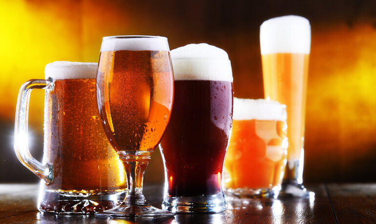 Craft beers on a wooden table, symbolizing the diversity of craft beer and its role in culture and academic research