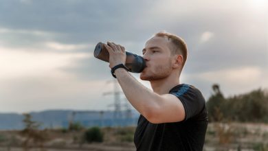 A marathon runner drinking water from a hydration pack while running