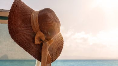 Female leather hat hanging under the sun on a beach, with the ocean in the background