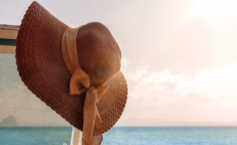 Female leather hat hanging under the sun on a beach, with the ocean in the background