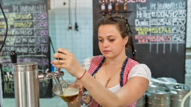 Female brewer pouring beer at a San Diego brewery, illustrating women's participation in brewing