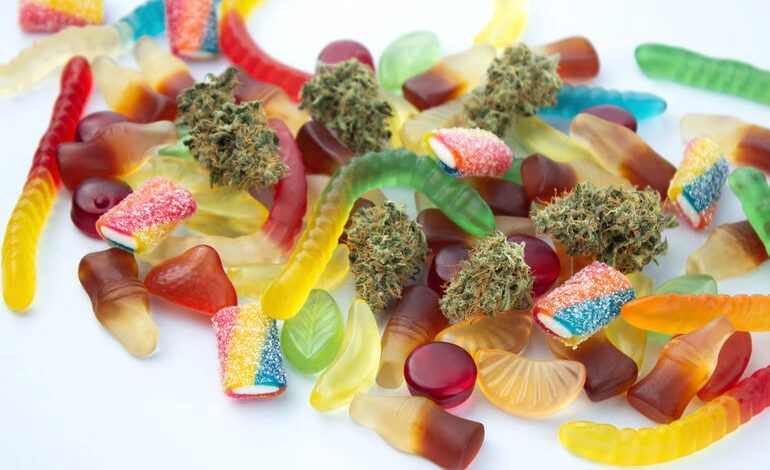 Assorted weed-infused gummies in various shapes and colors