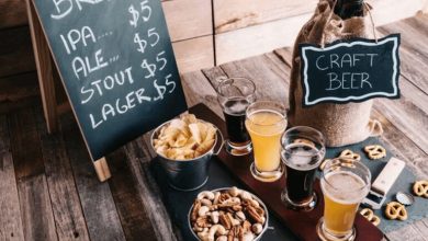 A rustic brewery business setup featuring craft beer, a menu board, and snack pairings