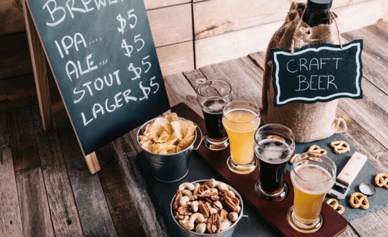 A rustic brewery business setup featuring craft beer, a menu board, and snack pairings