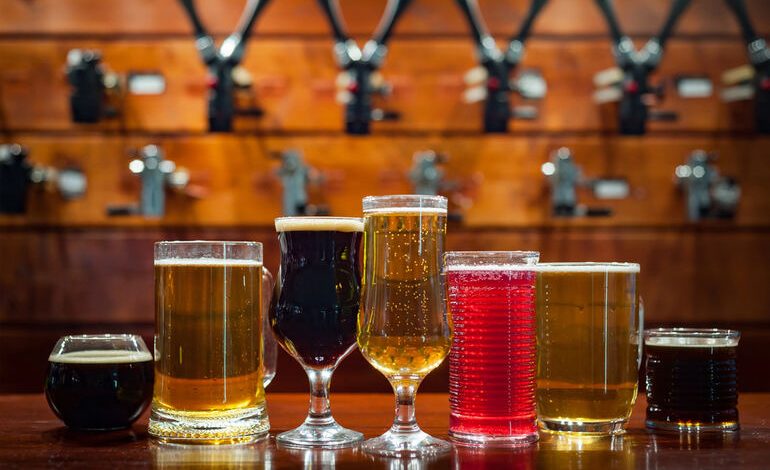 Assorted craft beers in different glasses at a financially strong brewery taproom