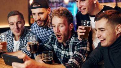 Group of friends enjoying beer while playing online games in a San Diego bar