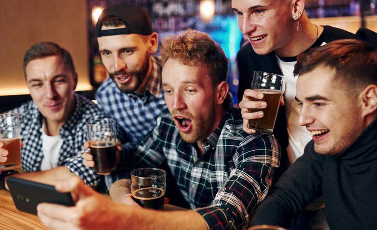 Group of friends enjoying beer while playing online games in a San Diego bar