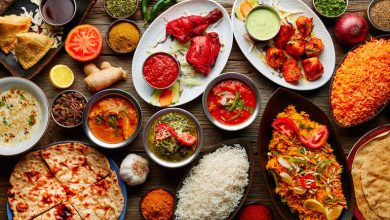 An assortment of flavorful indian cuisine, including curries, naan, rice, and spices