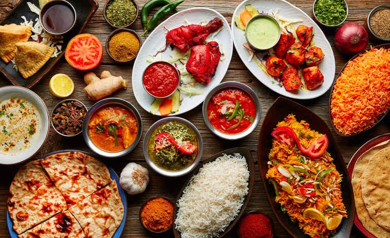 An assortment of flavorful indian cuisine, including curries, naan, rice, and spices