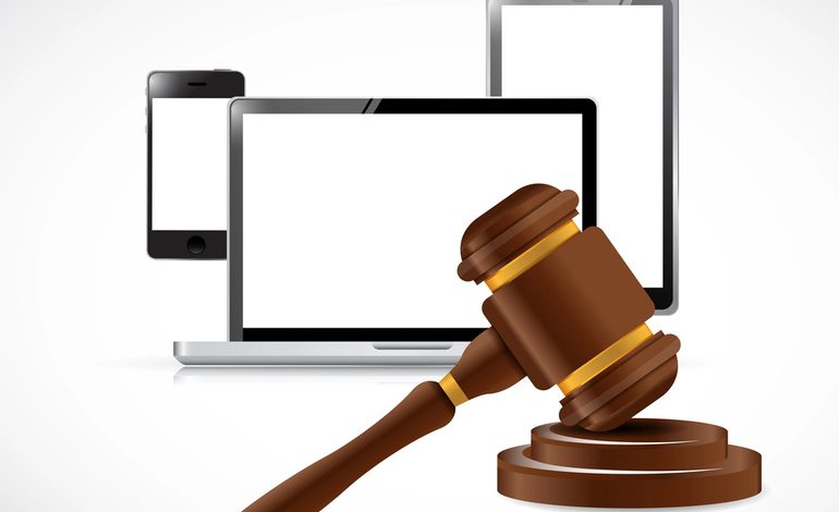 Gavel in front of digital devices symbolizing legality and regulation
