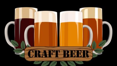 Four beer mugs with frothy tops and a wooden "Craft Beer" label