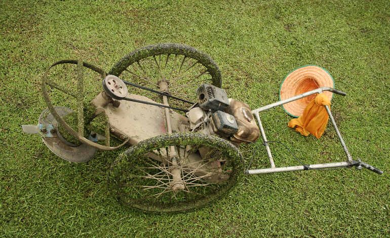 Old or damaged lawn mower belt flipped over on grass