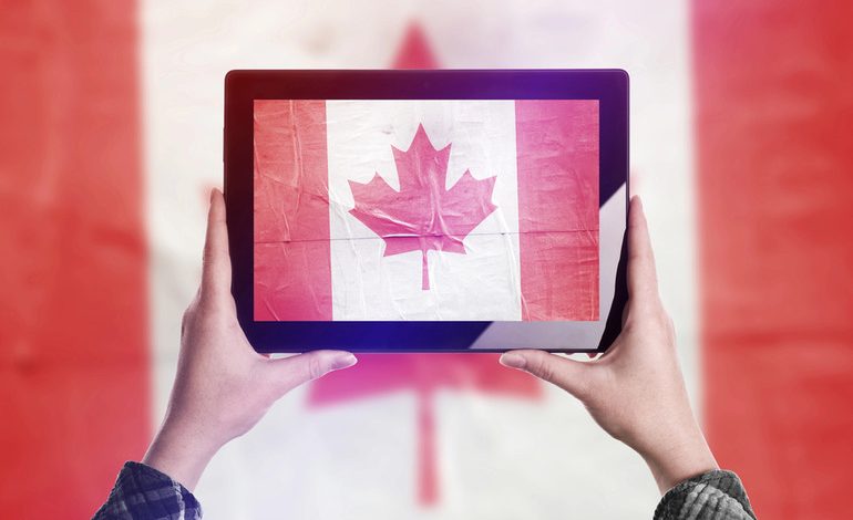 Person holding tablet displaying Canadian flag