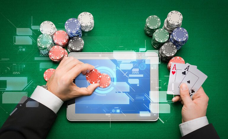 A person playing online poker on a tablet with poker chips and playing cards, representing the shift from traditional table games to digital casino platforms.