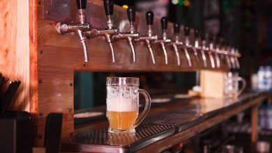 A row of beer taps at a San Diego brewery with a freshly poured glass of craft beer, highlighting local brewing culture and house yeast strains