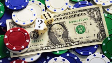 A one-dollar bill surrounded by poker chips and dice, symbolizing low-stakes online gambling