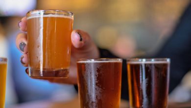 Close-up of a beer with a hand holding a tasting glass at a San Diego brewery
