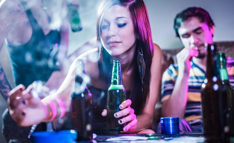 Young adults enjoying craft beer and cannabis vapes in a relaxed social setting