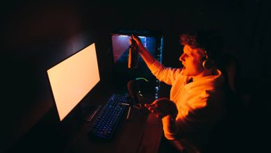 Gamer enjoying beer while playing online slots on a desktop setup.