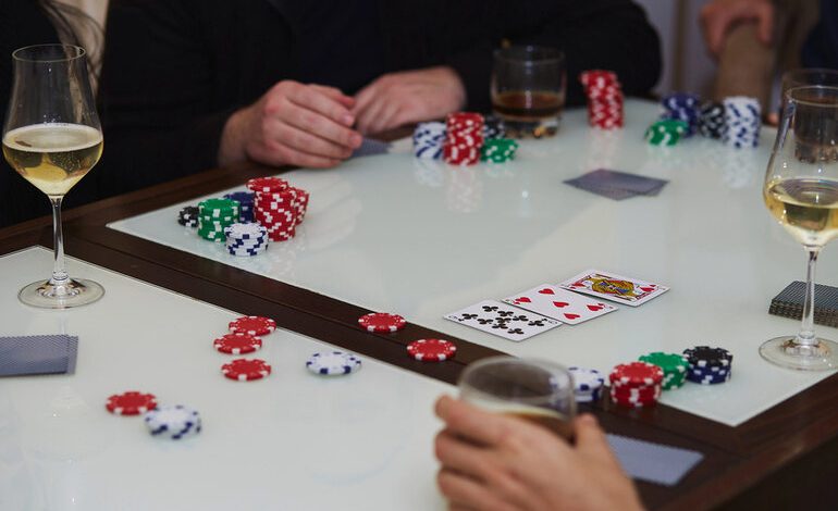 Friends enjoying a lively poker night with stacks of chips, playing cards on the table, and glasses of beer, perfect for beer-loving game enthusiasts.