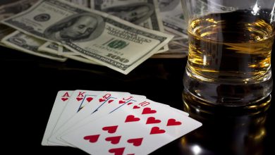 Poker hand with cash and a beer glass symbolizing a smart gambling strategy.
