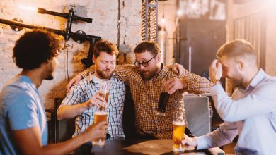 Beer enthusiasts enjoying craft beers together in a cozy pub, laughing and bonding over drinks.