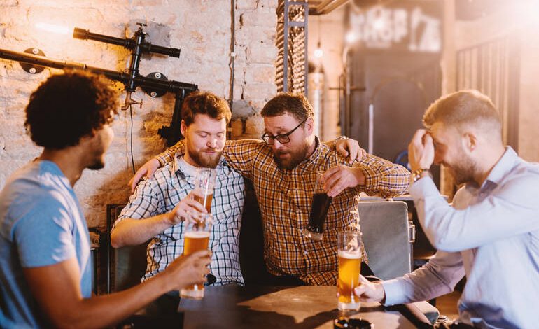 Beer enthusiasts enjoying craft beers together in a cozy pub, laughing and bonding over drinks.
