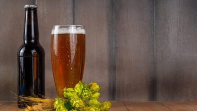 A bottle of whiskey and a glass of beer with hops, barley