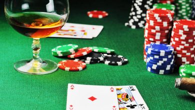 Glass of whiskey, poker cards, and colorful chips on a casino table symbolizing smarter gambling choices by drinking less alcohol.