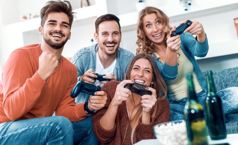 Friends enjoying video games together with beers and snacks