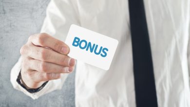 A person in a white shirt and tie holding a card with the word BONUS, symbolizing a no-deposit bonus and promo code offer for casino players.