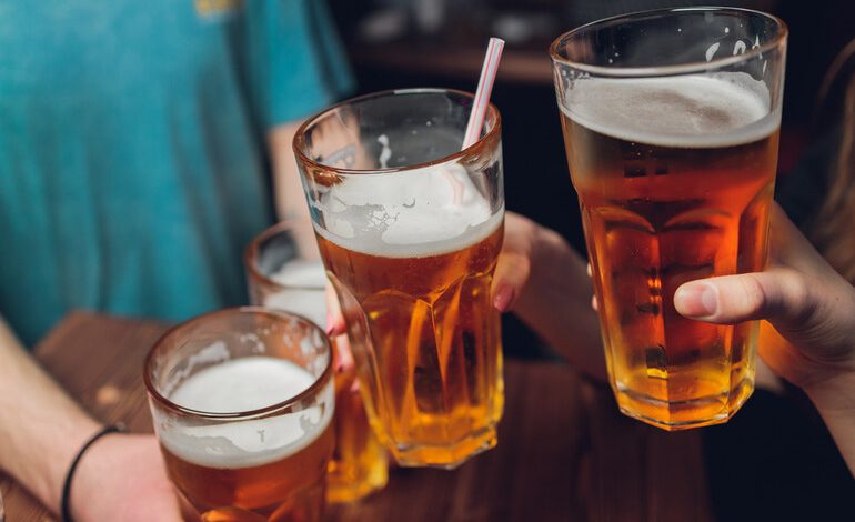 Friends clink glasses of craft beer at a local bar, using their favorite brews as a new kind of social currency in the community.