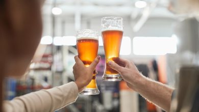 Two people holding craft beer glasses, celebrating money-savvy drinking habits.