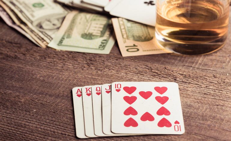 Cards, cash, and a glass of beer on a table