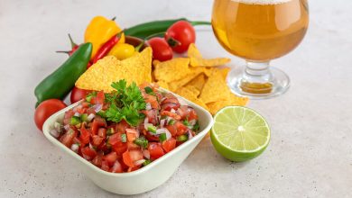 Fresh homemade salsa with tortilla chips, lime, and a glass of beer