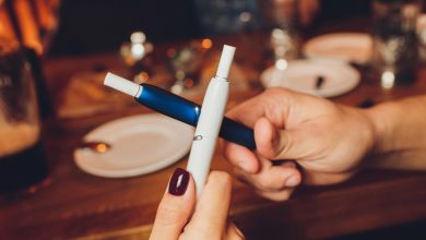 A couple holding two vape devices in a bar in San Diego
