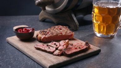 A plate of grilled meat and a glass of beer.