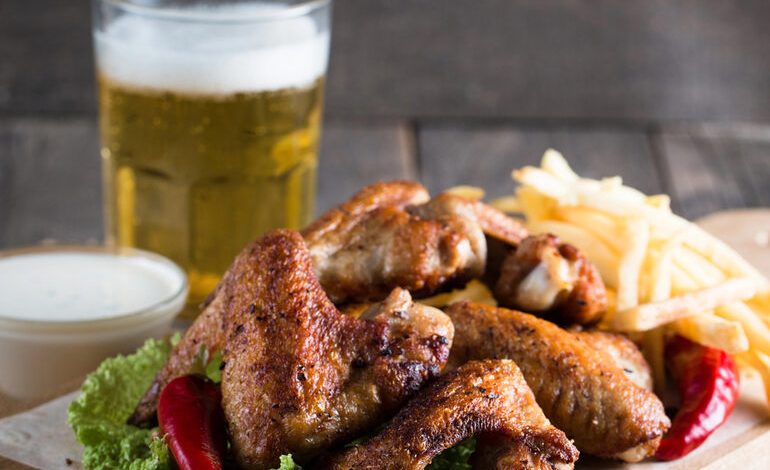 Crispy chicken wings, dipping sauce, fries, and a glass of beer are ideal during festivals and beer party events.