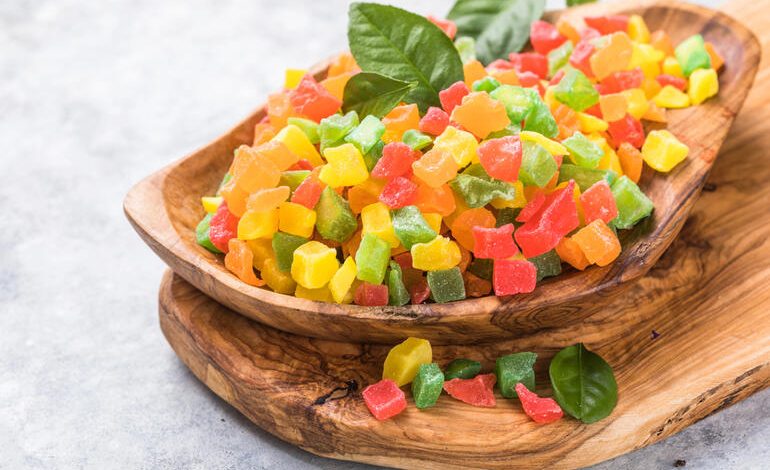 Colorful fruit-flavored gummy pieces in a wooden bowl, used to illustrate how CBD gummies can enhance the season for beer lovers.