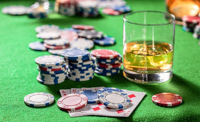 Craft beer alongside poker chips and playing cards representing modern casino gaming culture.