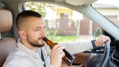 The man holding a beer bottle as he drives a car depicts a case of dangerous drunk driving in Charlotte.
