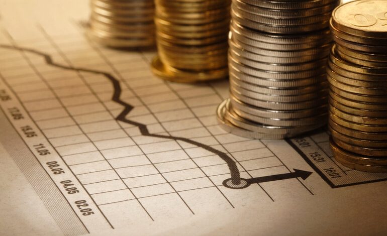 A stack of coins on an exchange rate sheet.
