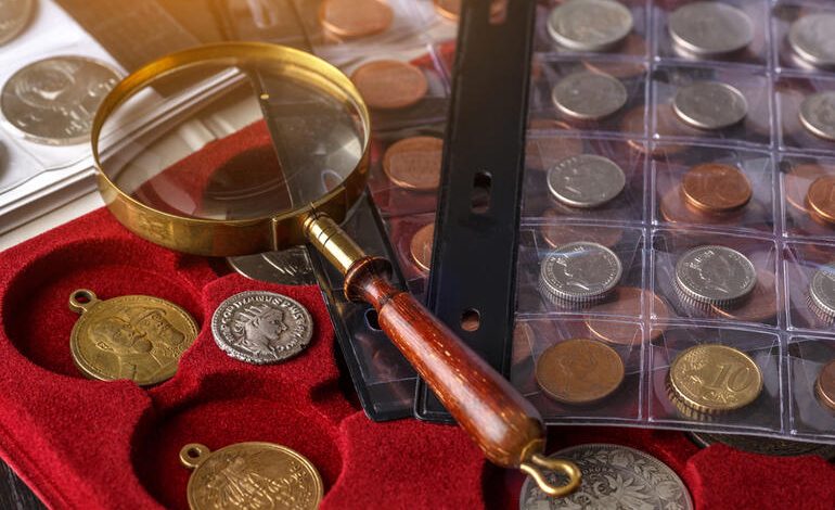 In the picture, there is a magnifying glass on a coin collection with albums and trays that symbolize the research on coin identification and value.