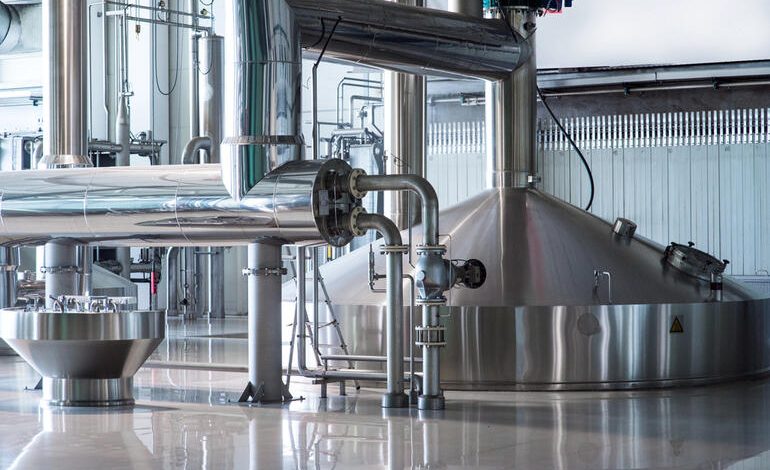 Modern brewery interior with stainless steel fermentation tanks and piping