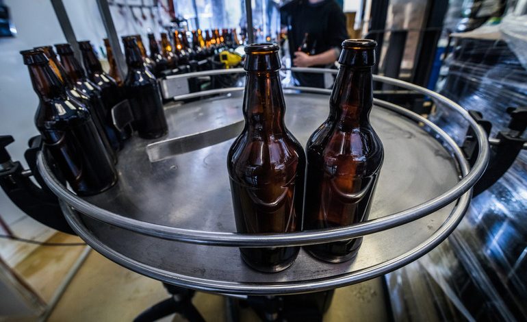 Beer bottles being filled in a brewery system.