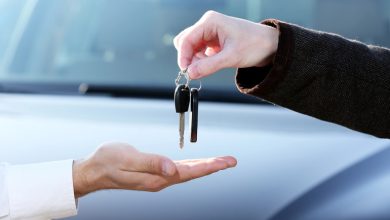 A man is receiving a car key after buying a new car.