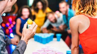A group of friends is playing beer pong at a bar.