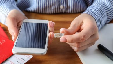 A man is inserting a SIM card into his phone.