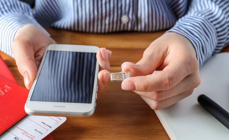 A man is inserting a SIM card into his phone.